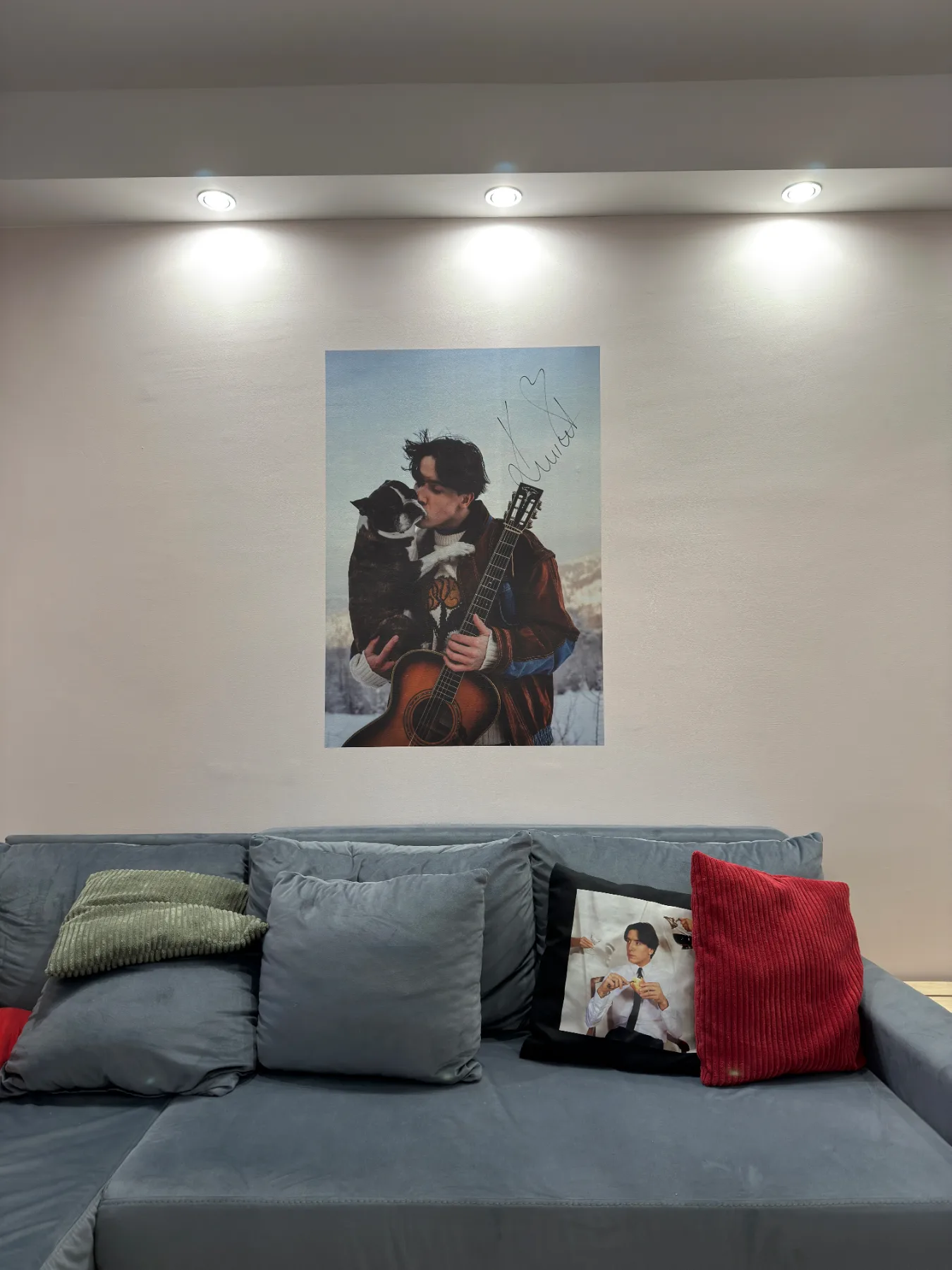 Wielkoformatowy plakat wydrukowany bezpośrednio na ścianie nad kanapą w salonie, podświetlony punktowo